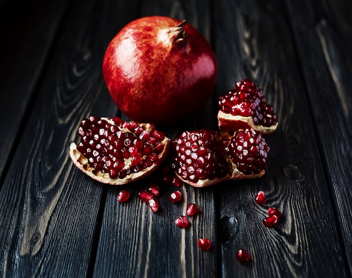 Open pomegranates on a dark table