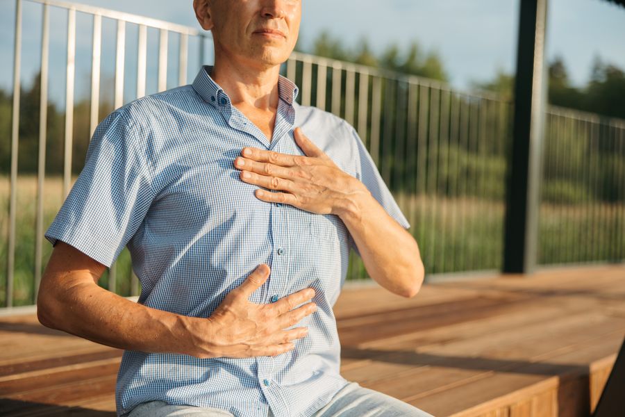 Man with one hand on his chest and one on his abdomen breathing calmly