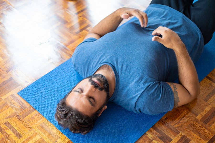 Man lying on his back on a blue mat